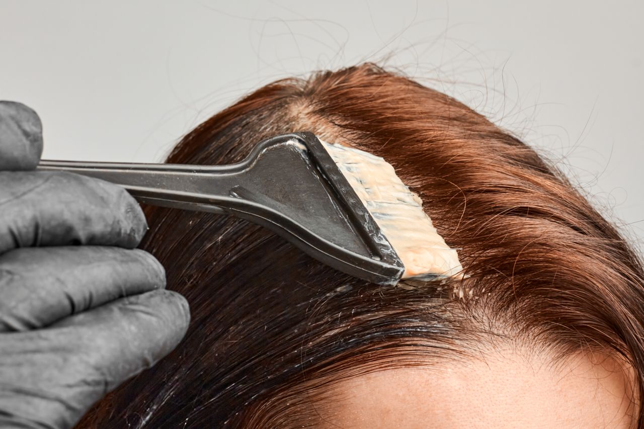 Friseur trägt Ansatzfarbe auf