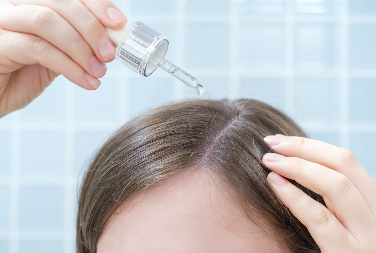 Kopfhautserum Aromaöl: Calming Aroma Complex Frau trägt sich ein Kopfhautserum auf