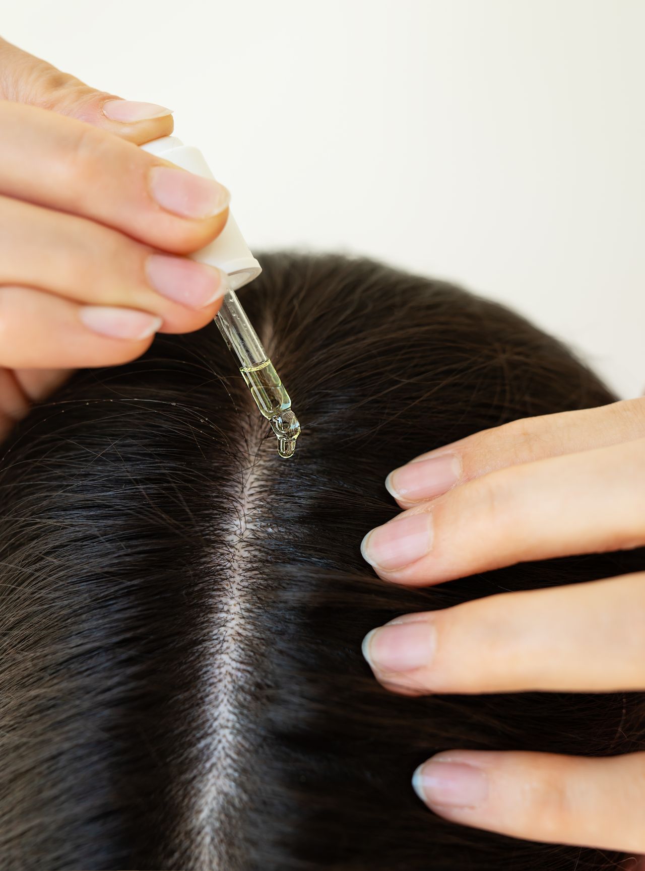 Kopfhautserum wird mit der Pipette auf den Scheitel aufgetragen – Haar- und Kopfhautpflege bei Kramer Hair in Braunschweig