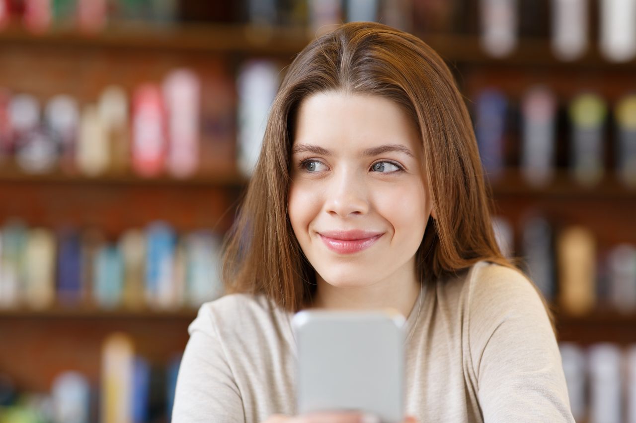 Kundin bucht am Smartphone einen Friseurtermin online bei Kramer Hair in Braunschweig