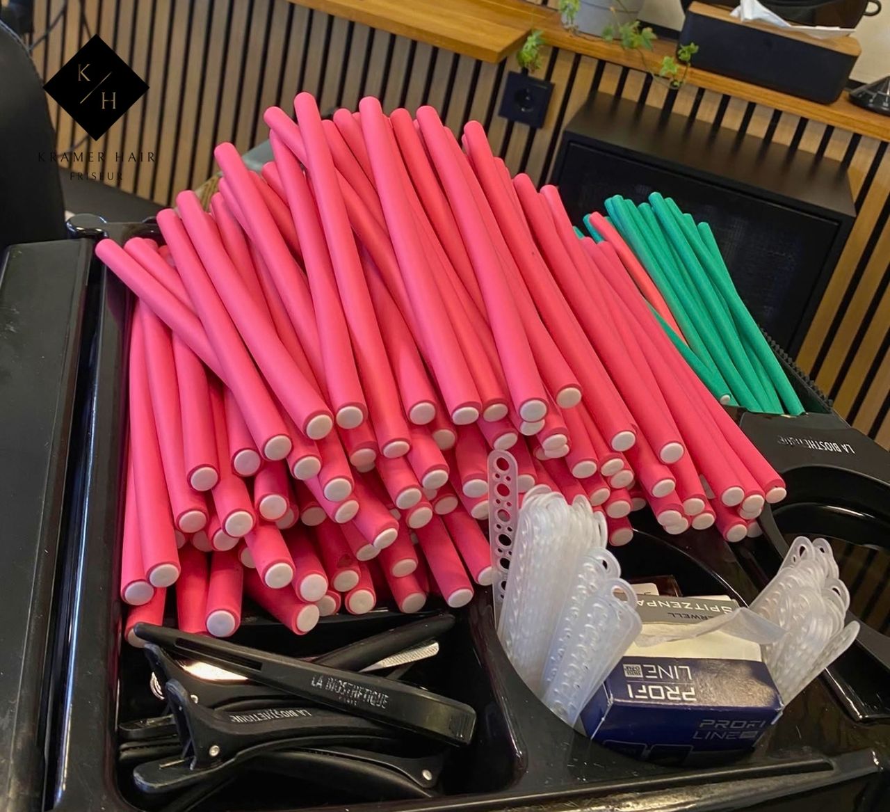Arbeitswagen im Salon Kramer Hair Braunschweig mit vielen pinken und grünen biegsamen Papilotten, Abteilklammern und Spitzenpapier für eine Spiraldauerwelle