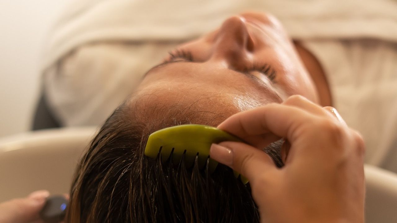 Pflegebehandlung am Waschbecken im Friseursalon