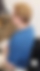 Dame mit Kurzhaarschnitt sitzt auf Stuhl 