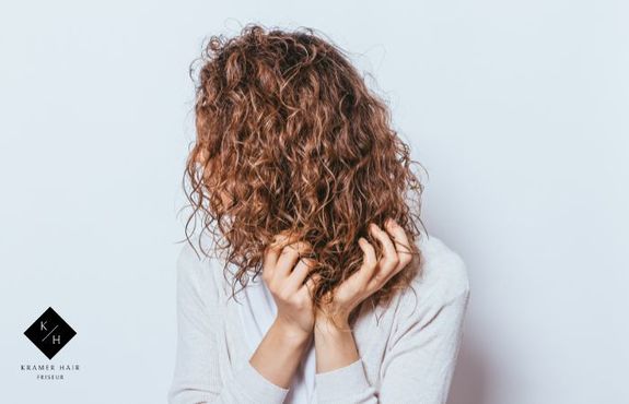 Dame knetet in den Haaren einer frischen Dauerwelle 