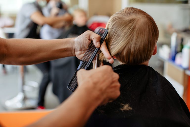 Bei einem Kind werden die Haare am Hinterkopf geschnitten